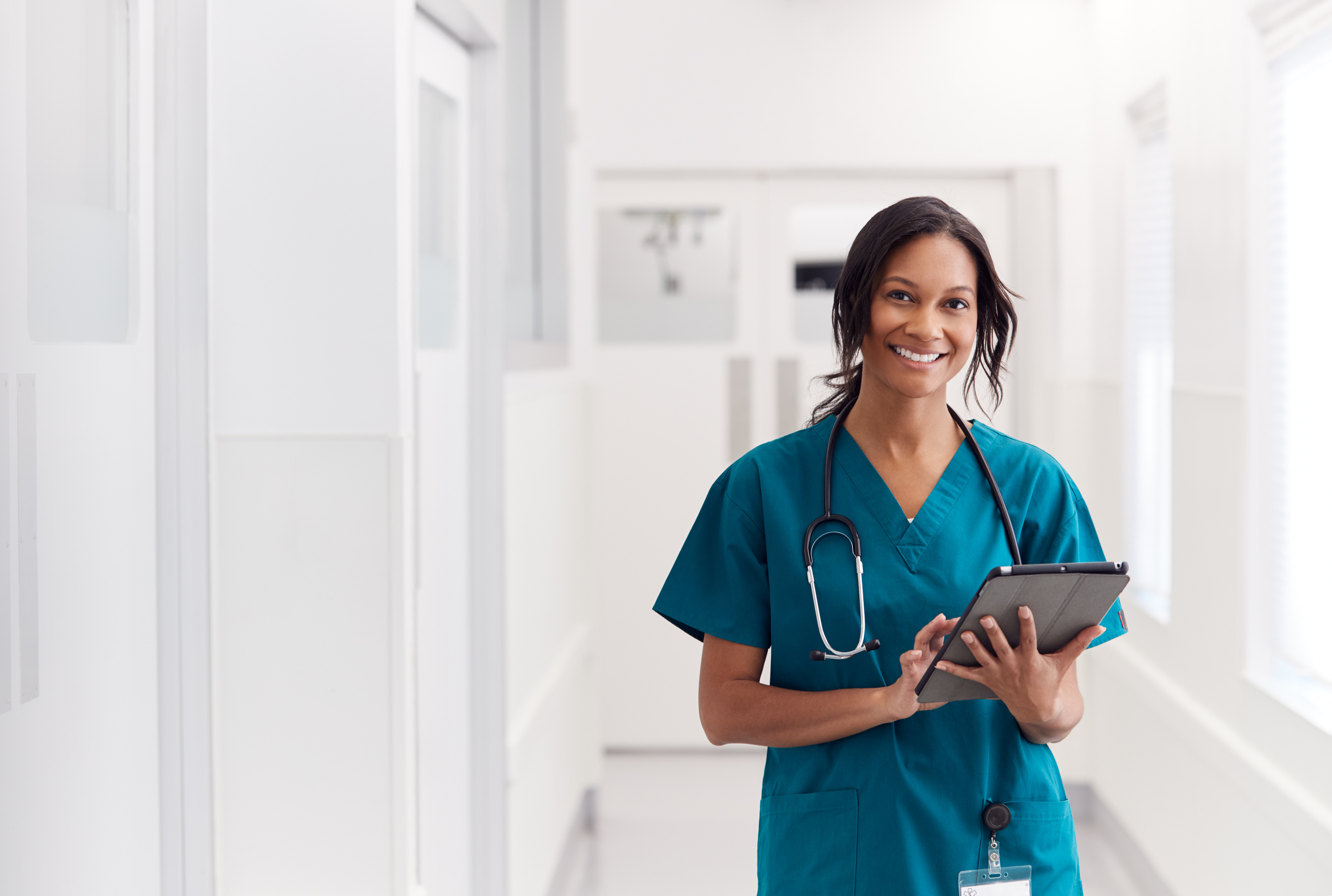 Qualifizierte internationale Pflegekraft mit Tablet in deutscher Klinik